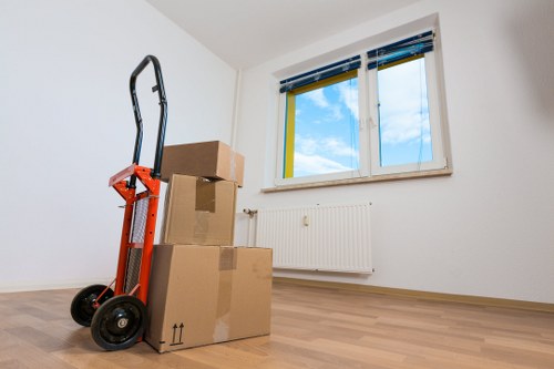 Removal professionals navigating stairs during a flat move in Earlscourt